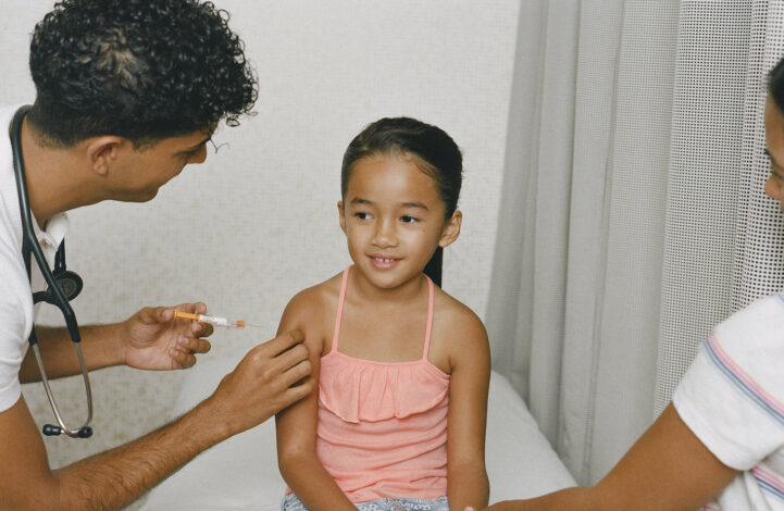Happy child receives a vaccination from a doctor